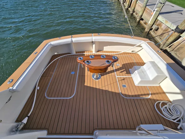  Yacht Photos Pics Post 47 Convertible 2000 boat deck with wooden flooring and fishing rod holders.