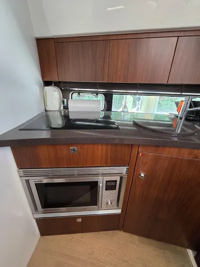  Yacht Photos Pics 2013 Fairline Targa 38 Open yacht kitchen with microwave and wooden cabinets.