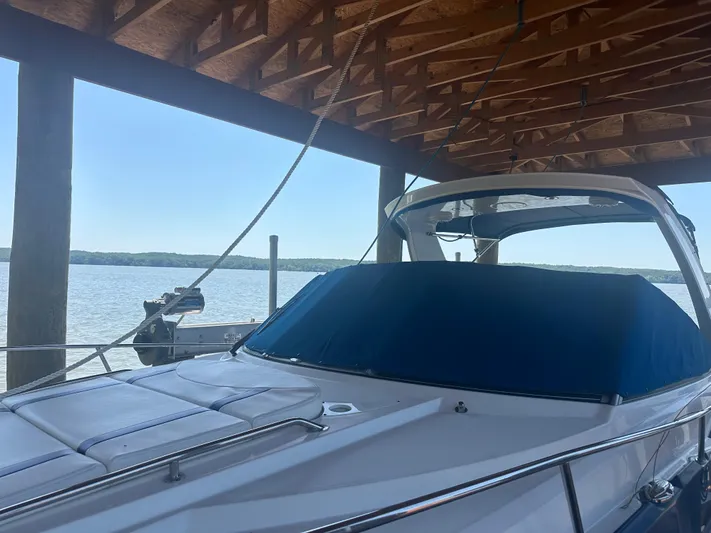 Always Flo&rsquo;n Yacht Photos Pics 2019 Monterey 295 Sport Yacht docked under a wooden canopy by the water.