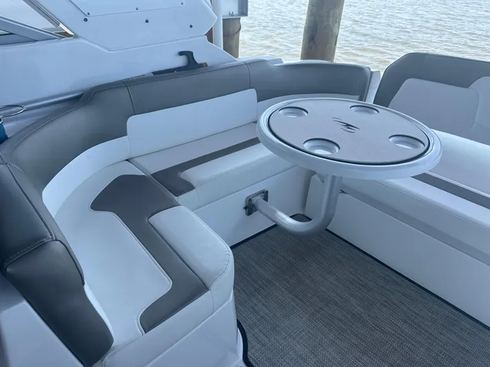 Always Flo&rsquo;n Yacht Photos Pics 2019 Monterey 295 Sport Yacht interior with cushioned seating and round table by the water.