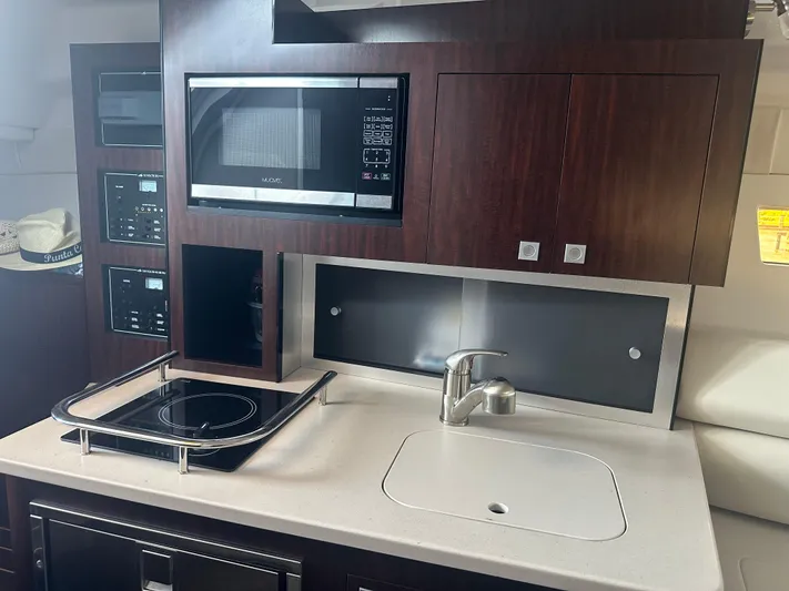 Always Flo&rsquo;n Yacht Photos Pics 2019 Monterey 295 Sport Yacht kitchen with microwave, stove, and sink.