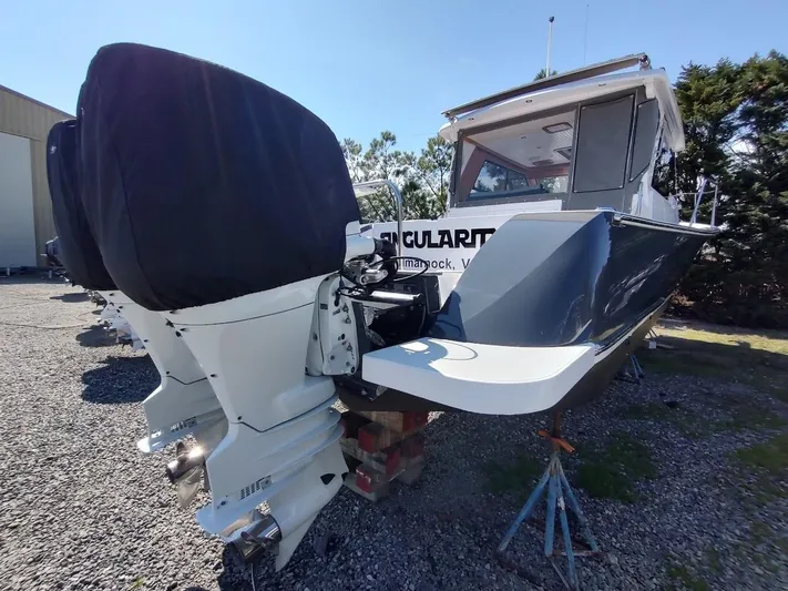 Singularity Yacht Photos Pics 2022 True North 34 boat with dual outboard motors on a gravel lot.