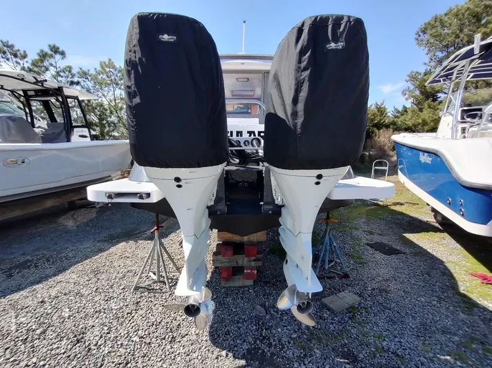 Singularity Yacht Photos Pics 2022 True North 34 boat with covered outboard motors, parked on gravel.