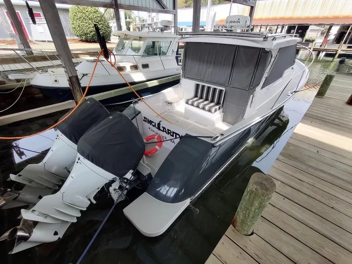 Singularity Yacht Photos Pics True North 34 boat, 2022 model, docked with twin outboard engines, covered seating area.