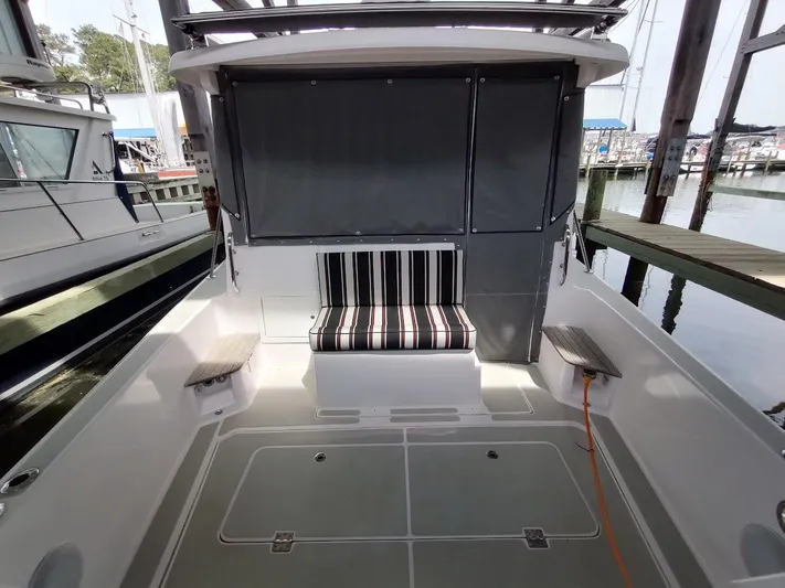 Singularity Yacht Photos Pics 2022 True North 34 boat interior with striped seating, docked at marina.