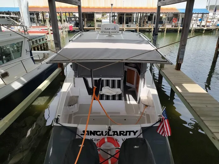 Singularity Yacht Photos Pics True North 34 boat docked, rear view with canopy, American flag, and Garmin equipment, 2022 model.