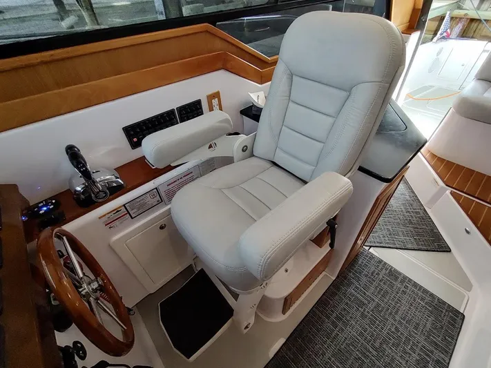 Singularity Yacht Photos Pics Captain's chair in 2022 True North 34 boat cockpit, featuring controls and steering wheel.