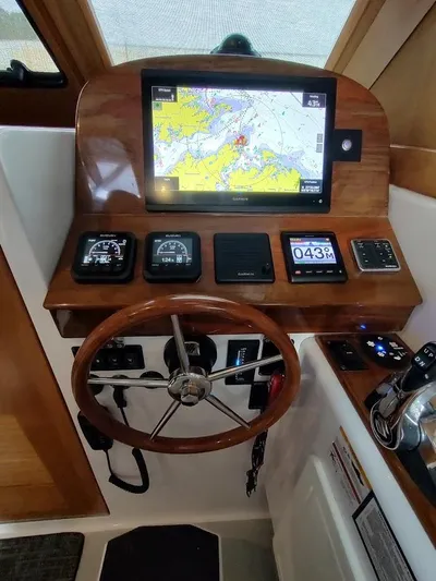 Singularity Yacht Photos Pics 2022 True North 34 boat helm with navigation screen, gauges, and wooden steering wheel.