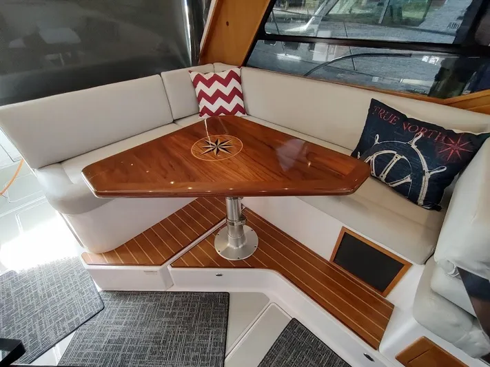 Singularity Yacht Photos Pics Luxurious 2022 True North 34 yacht interior with elegant wooden table and cozy seating.