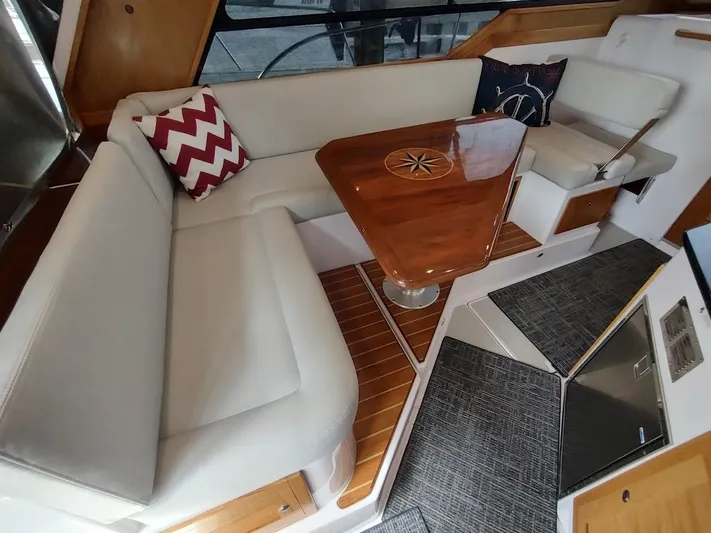 Singularity Yacht Photos Pics Interior of a 2022 True North 34 boat with elegant seating and wooden table.