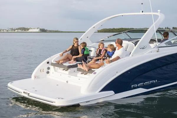  Yacht Photos Pics Family enjoying a 2016 Regal 3200 Bowrider boat on a calm lake.