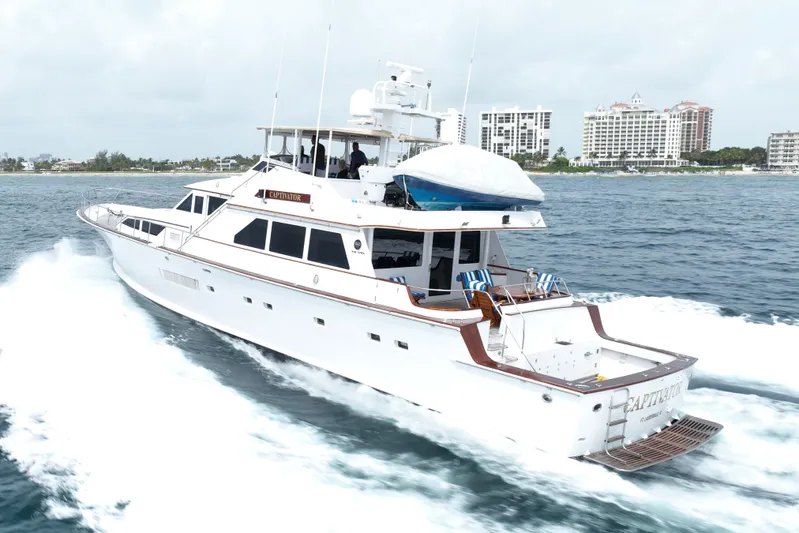 Captivator Yacht Photos Pics 1984 Palmer Johnson Motor Yacht cruising on the ocean near a coastal cityscape.