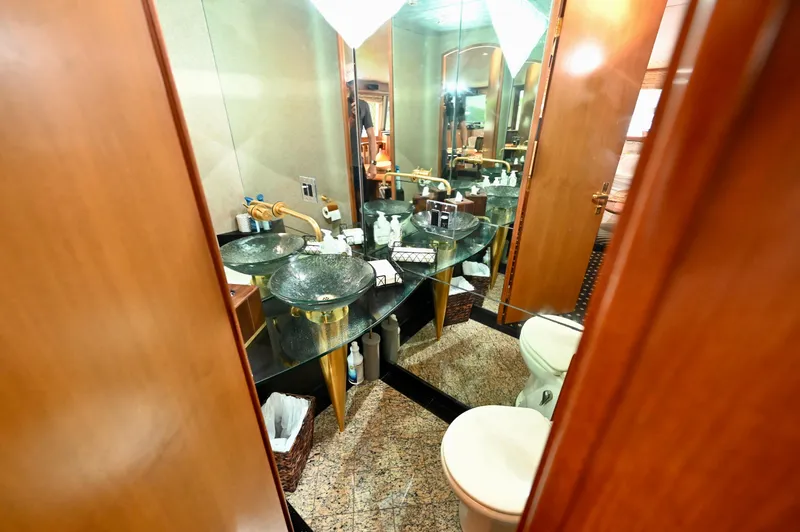 Captivator Yacht Photos Pics Luxurious bathroom on a 1984 Palmer Johnson motor yacht with elegant fixtures and glass sink.