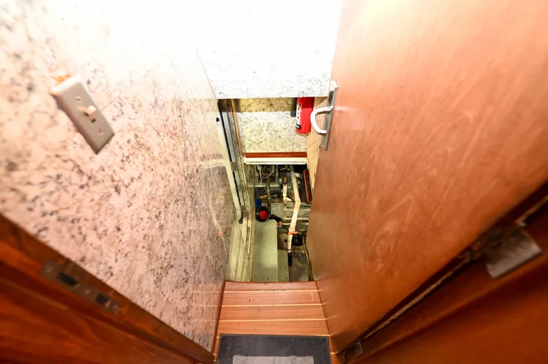 Captivator Yacht Photos Pics Engine room access on 1984 Palmer Johnson Motor Yacht, featuring wooden door and visible machinery.