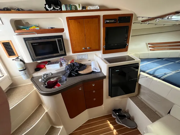  Yacht Photos Pics 2009 Grady-White Express 330 cabin interior with kitchenette, microwave, and seating area.