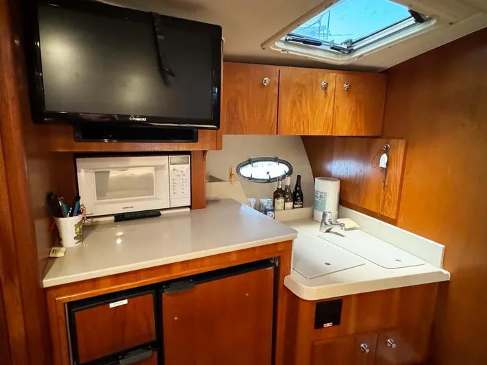 Rhumb Line Yacht Photos Pics Interior of 2000 Tiara Sport 3500 Open yacht with kitchenette and TV.