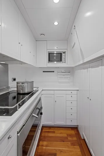 Archipelago Yacht Photos Pics Compact white kitchen in a 2005 Moonen Displacement Yacht with modern appliances and wooden flooring.