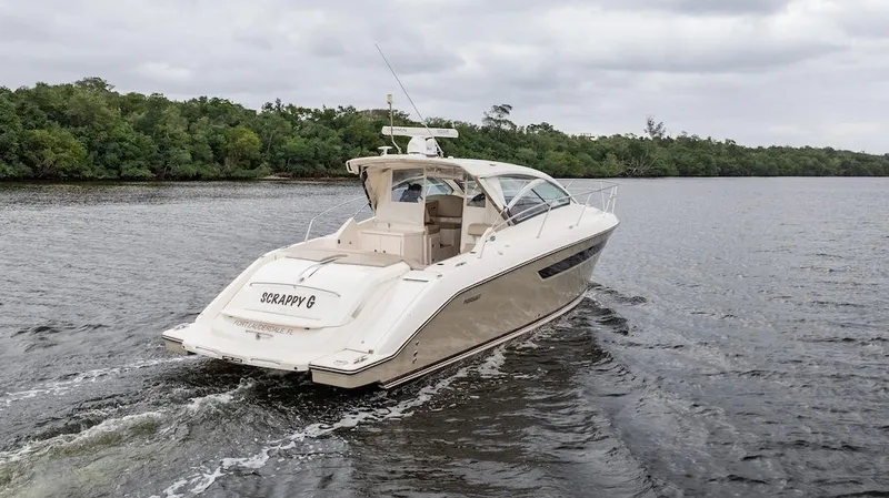Scrappy G Yacht Photos Pics 2015 Pursuit SC 365i Sport Coupe cruising on a calm river with lush green shoreline.