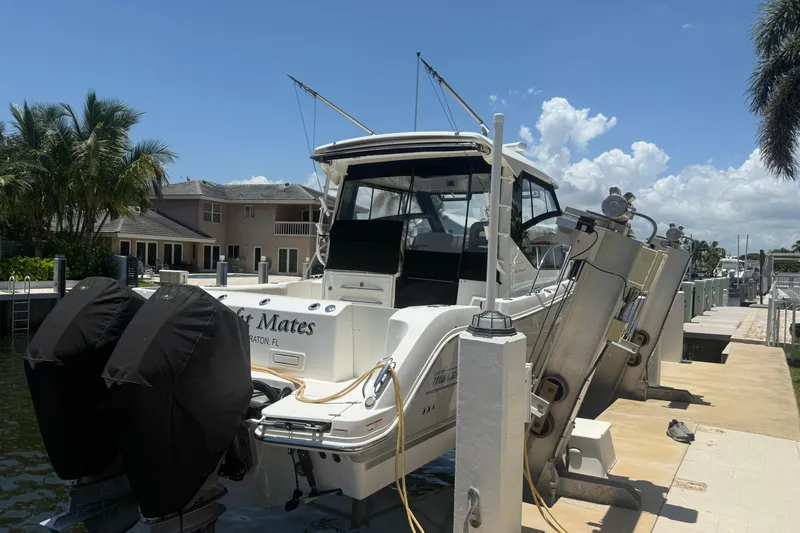  Yacht Photos Pics 2021 Boston Whaler 325 Conquest docked, featuring dual outboard motors, under a clear blue sky.