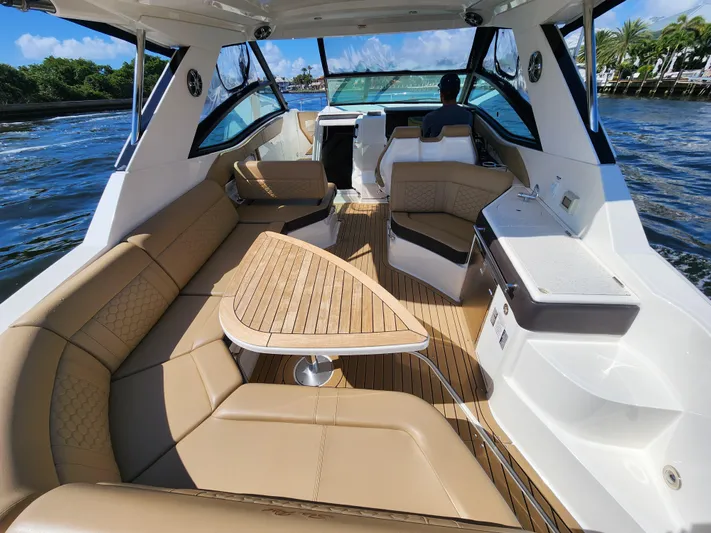  Yacht Photos Pics 2021 Sea Ray 320 Sundancer interior with tan seating and wooden table on the water.