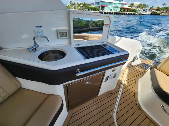  Yacht Photos Pics Outdoor kitchenette on a 2021 Sea Ray 320 Sundancer yacht with sink and grill.