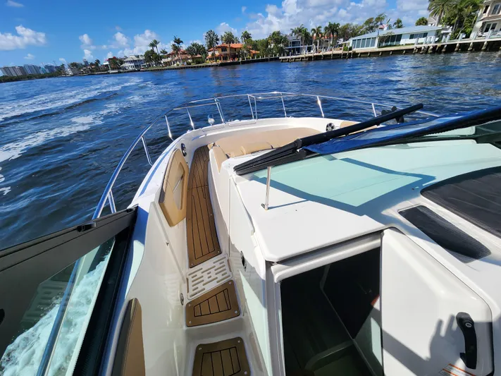  Yacht Photos Pics 2021 Sea Ray 320 Sundancer cruising on a sunny day near waterfront homes.