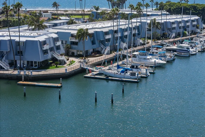 Cynful One Yacht Photos Pics Marina with yachts, including a 1982 Viking 44 Motor Yacht, near modern waterfront buildings.