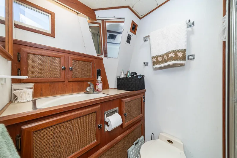 Cynful One Yacht Photos Pics 1982 Viking 44 Motor Yacht bathroom with wooden cabinets and modern amenities.