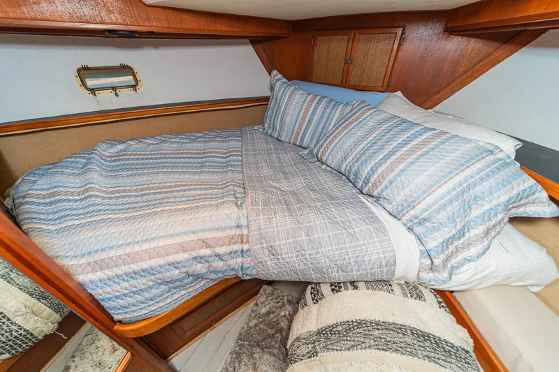 Cynful One Yacht Photos Pics Cozy cabin bedroom in 1982 Viking 44 Motor Yacht with striped bedding.