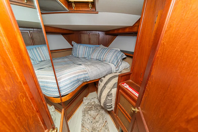 Cynful One Yacht Photos Pics Cozy cabin interior of 1982 Viking 44 Motor Yacht with wood paneling and striped bedding.