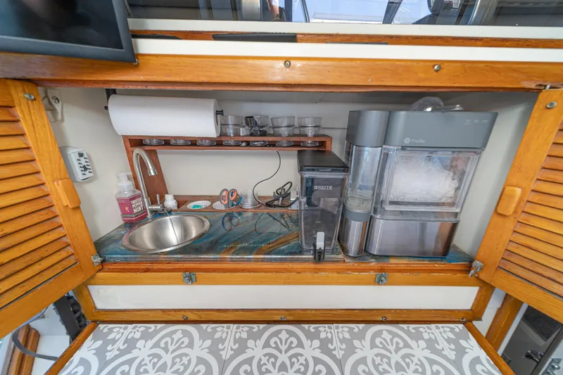 Cynful One Yacht Photos Pics Compact kitchenette on 1982 Viking 44 Motor Yacht with sink, ice maker, and storage.