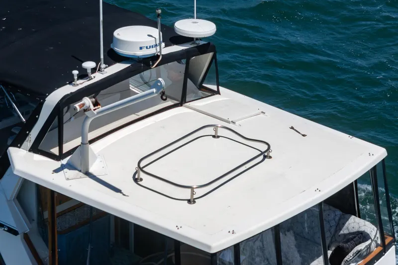 Cynful One Yacht Photos Pics 1982 Viking 44 Motor Yacht roof with radar equipment, cruising on blue water.