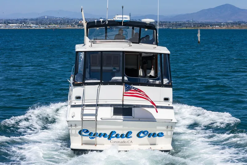 Cynful One Yacht Photos Pics 1982 Viking 44 Motor Yacht sailing with American flag in Coronado waters.
