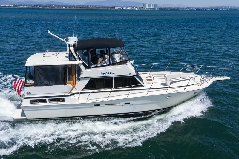Cynful One Yacht Photos Pics 1982 Viking 44 Motor Yacht cruising on open water, American flag displayed.