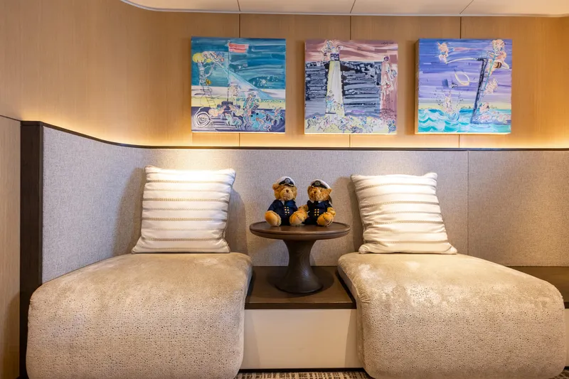 Grand Cru Yacht Photos Pics Luxurious Baglietto 49M yacht interior with plush seating, decorative pillows, and colorful artwork.