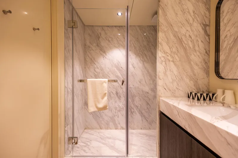 Grand Cru Yacht Photos Pics Luxurious marble bathroom on Baglietto 49M yacht, featuring a glass shower and elegant vanity.