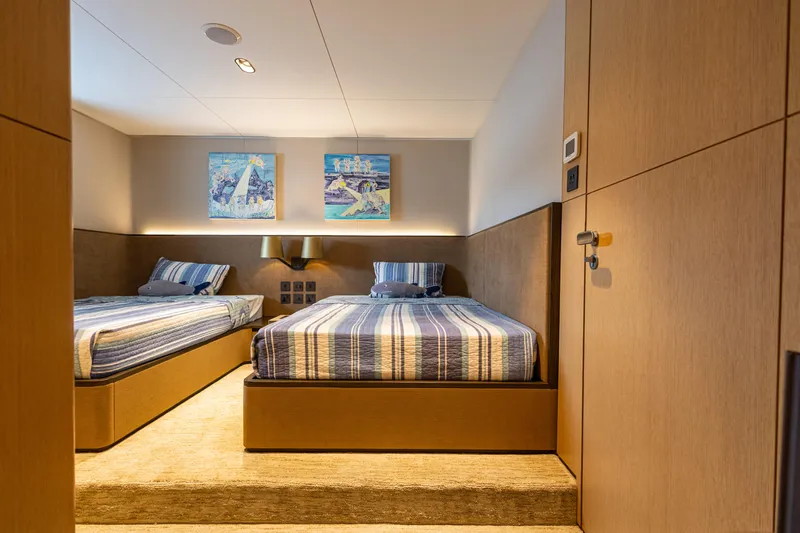 Grand Cru Yacht Photos Pics Luxurious twin bedroom on 1995 Baglietto 49M yacht with modern decor and artwork.