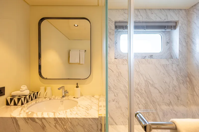 Grand Cru Yacht Photos Pics Luxurious yacht bathroom with marble sink, mirror, and window on Baglietto 49M, 1995 model.
