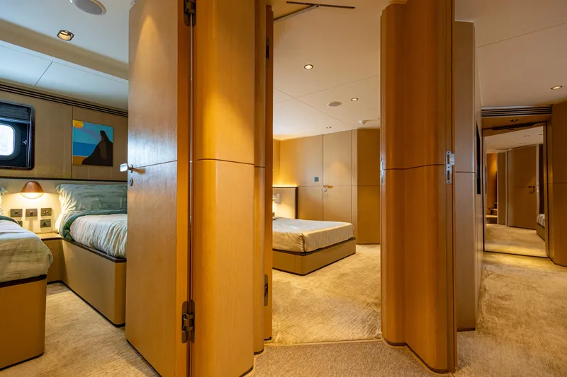 Grand Cru Yacht Photos Pics Luxurious interior of 1995 Baglietto 49M yacht with modern wood paneling and cozy bedrooms.