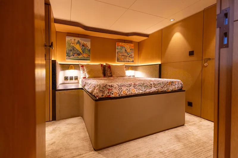 Grand Cru Yacht Photos Pics Luxurious bedroom interior on 1995 Baglietto 49M yacht, featuring elegant decor and ambient lighting.