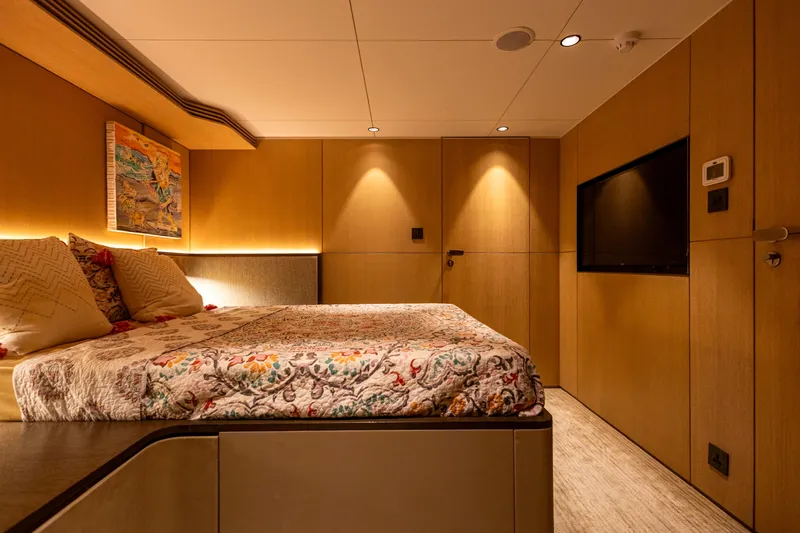 Grand Cru Yacht Photos Pics Luxurious bedroom interior on a 1995 Baglietto 49M yacht, featuring elegant wood paneling.