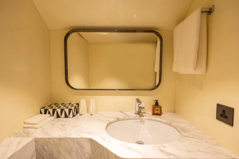 Grand Cru Yacht Photos Pics Luxurious bathroom on Baglietto 49M yacht, featuring marble countertop and modern fixtures, 1995 model.