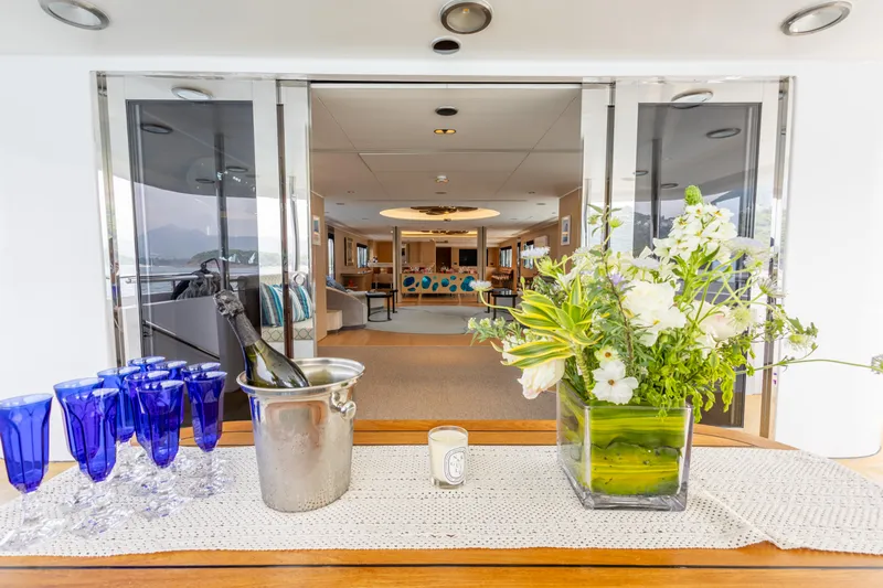 Grand Cru Yacht Photos Pics Luxurious Baglietto 49M yacht interior with flowers, champagne, and blue glasses, 1995 model.