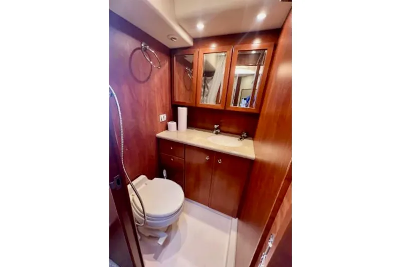 Seas The Reins Yacht Photos Pics Luxurious bathroom in 2006 Silverton 43 Sport Bridge yacht with wood cabinetry and modern fixtures.