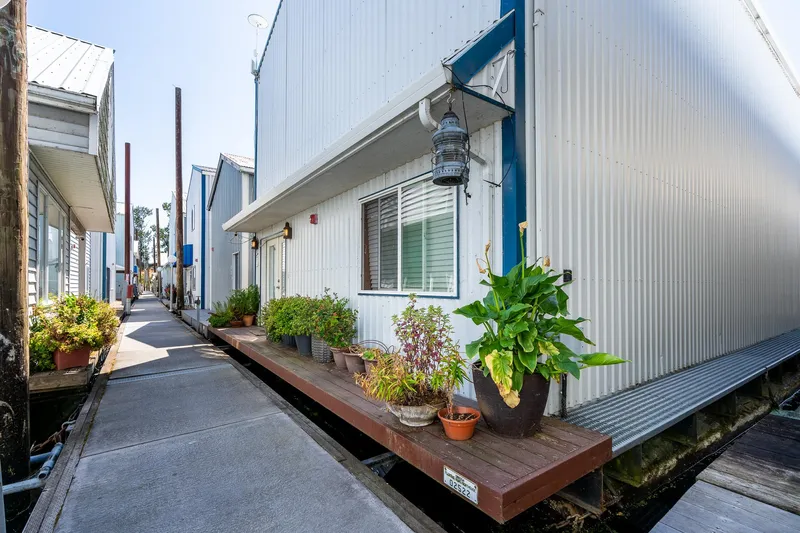  Yacht Photos Pics Custom Steelhead Boathouse 2006 with potted plants on a wooden deck by a walkway.