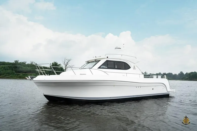  Yacht Photos Pics 2025 Bracewell Commander 36SF yacht on calm water under a cloudy sky.