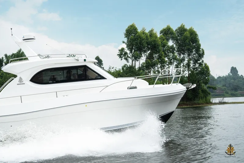  Yacht Photos Pics 2025 Bracewell Commander 36SF yacht cruising on a serene lake with lush greenery.