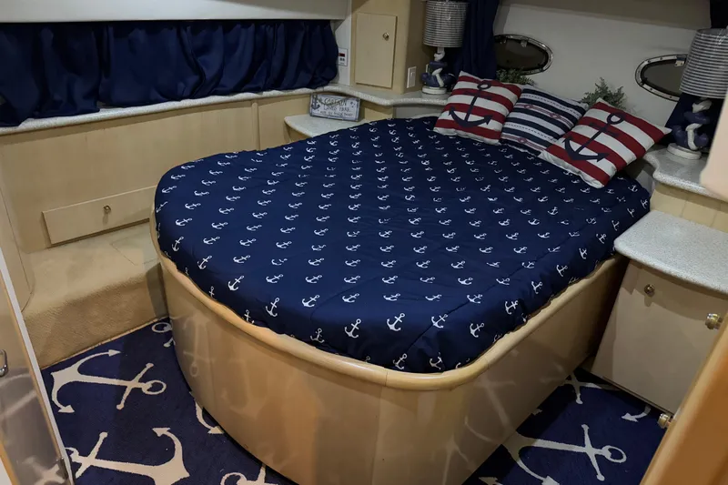 Allegedly Yacht Photos Pics Nautical-themed bedroom in 2000 Carver 396 Motor Yacht with anchor-patterned bedding and decor.
