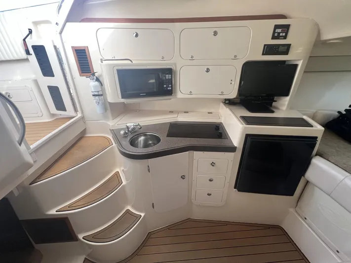  Yacht Photos Pics 2003 Grady-White Express 330 boat interior with kitchenette, featuring sink, microwave, and storage cabinets.