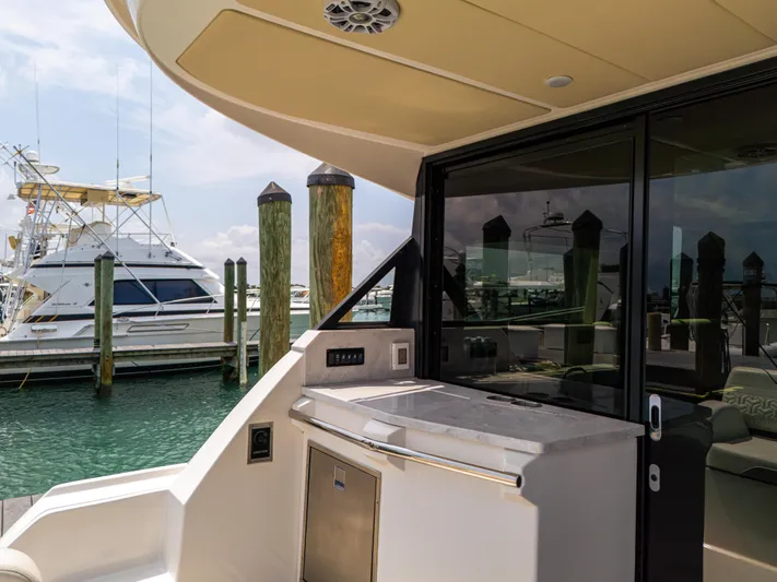  Yacht Photos Pics 2023 Regal 38 FXO yacht with sleek outdoor kitchen and marina view.